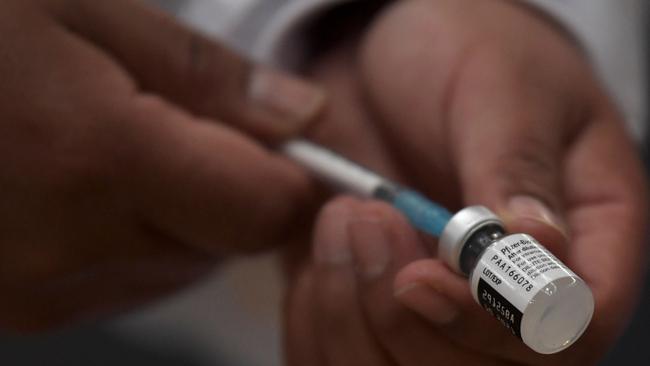 A health worker prepares to inoculate a pregnant woman with the Pfizer-BioNTech vaccine against COVID-19. (Photo by Raul ARBOLEDA / AFP)