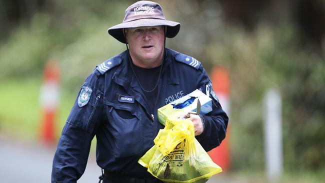 A police officer holds a hazardous waste bag. Picture: NCA NewsWire / Peter Lorimer.