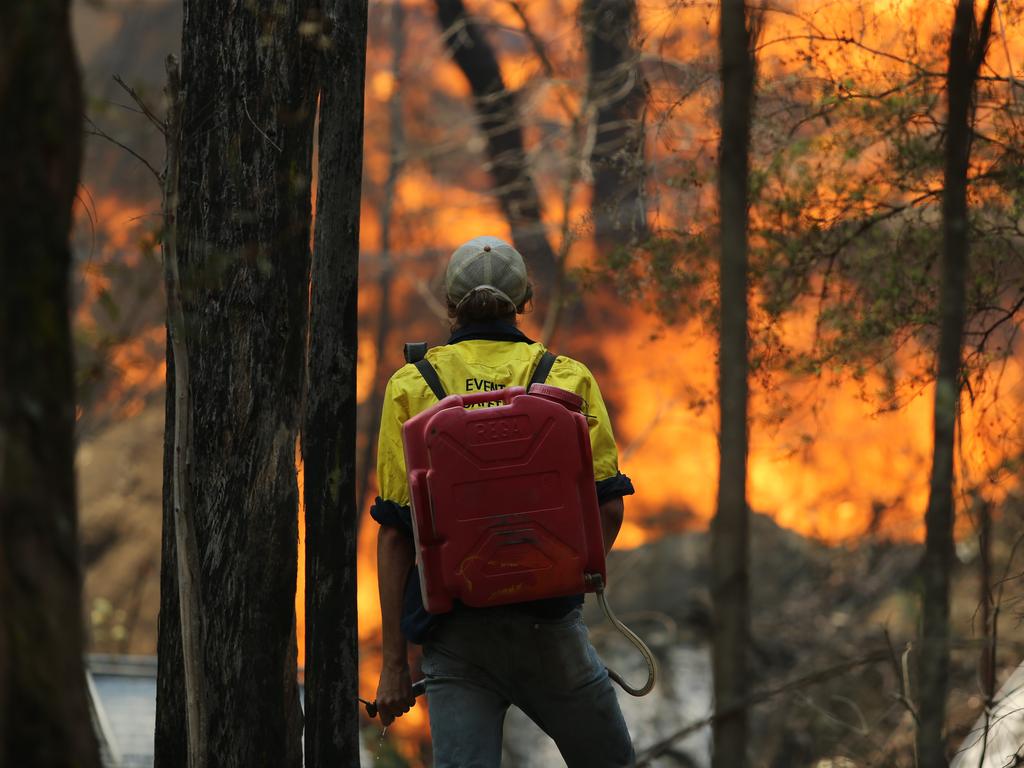 Pictured is a staff member trying to do his part to save Secret Creek Animal Sanctuary in Cobar Park near Lithgow today as the Bushfires continue to burn near the Blue Mountains. Picture: Tim Hunter