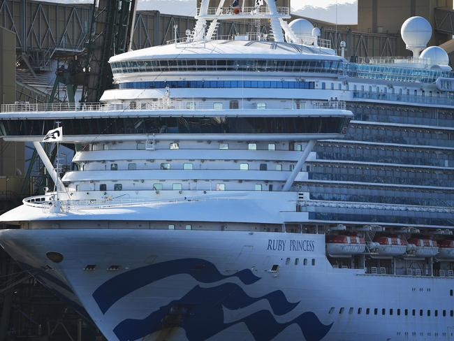 Cruise liner Ruby Princess docks at the harbour in Port Kembla, some 80 kilometres south of Sydney on April 12, 2020. - The Ruby Princess berthed after weeks stranded at sea to allow doctors to assess sick crew members and take the most serious cases ashore for medical treatment. (Photo by Saeed KHAN / AFP)