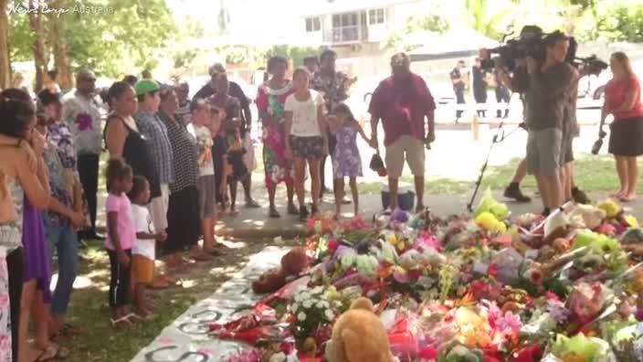 Community pays tribute to victims of Manoora massacre with flowers and song