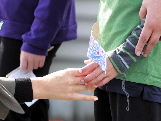 Meghan, Duchess of Sussex takes a paper flag from Joe Young. Picture: AP