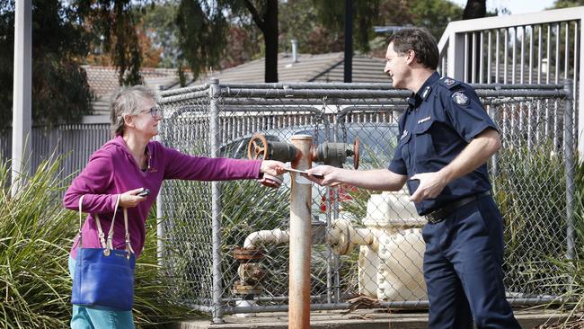 Deputy Commissioner Shane Patton is given a letter by a woman to pass on to the station after four officers were killed on the Eastern Freeway. Picture: David Caird