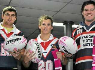 Cowboys players Hayden McNicol, Trent Achilles and Ryan Kinlyside with the pink socks and special edition footballs for today’s game. Picture: Erin Smith