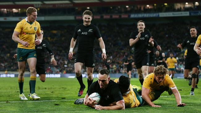 Israel Dagg of New Zealand scores a try against Israel Folau and Michael Hooper of Australia.