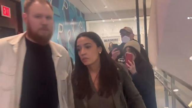 Alexandria Ocasio-Cortez and her fiance attempting to walk away from the protesters inside the cinema.