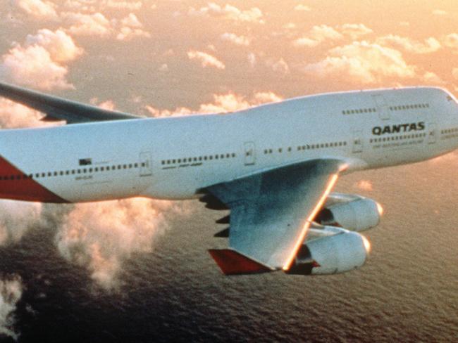 LIBRARY NOVEMBER, 1999 : Qantas Airlines Boeing 747-400 Jumbo plane with logo on tail, flies above clouds, 11/99. Australia / Aviation / Aircraft / Airline