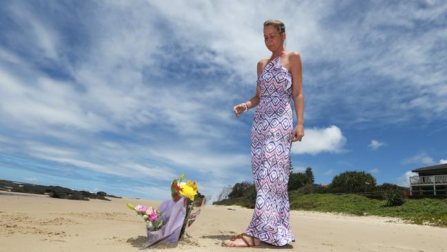 Former girlfriend Heidi Bell of Brisbane lays flowers as a tribute to shark attack victim Tadashi Nakahara at Shelly Beach Ballina Photograph: Jason O'Brien