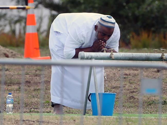 The first of the funerals is to take place today. Men wash themselves before the service begins. Picture: Gary Ramage