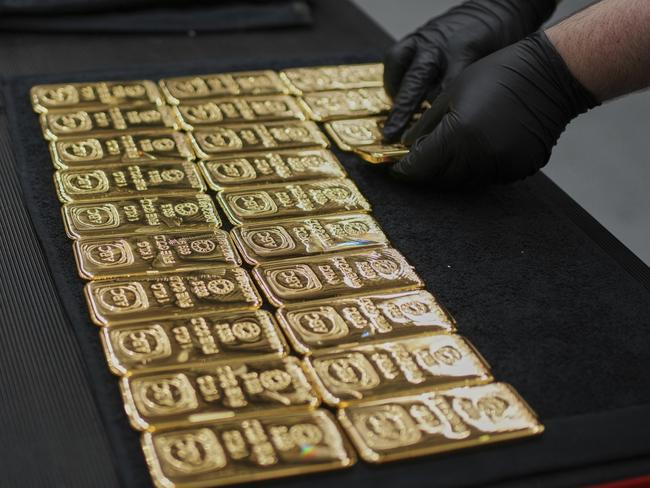 A worker lays out one kilogram gold cast bars with 99.99% purity ready for sale at the ABC Refinery in Sydney, Australia, Wednesday, April 30, 2025. (AP Photo/Mark Baker)
