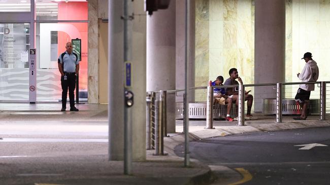 A security guard checks on people sitting outside of D Block at the Cairns Hospital at night. Picture: Brendan Radke