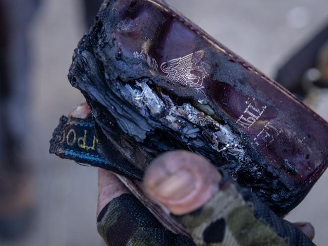 A member of the Ukrainian military holds the burnt remains of Russian passports. Picture: Getty Images