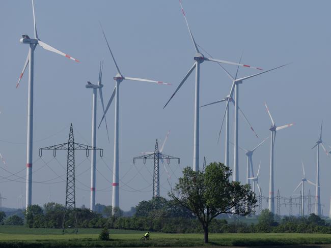 WEISSENFELS, GERMANY - MAY 09: Electricity pylons stand among wind turbines spinning at a wind farm on May 09, 2024 near Weissenfels, Germany. Germany is expanding its renewable energies production capacity, with annual goals for increases in wind and solar energy infrastructure. On any given day Germany produces between 30% and 65% of its electricity from wind and solar. The German government has set 2038 as the cutoff for shuttering its remaining coal-fired energy production.  (Photo by Sean Gallup/Getty Images)