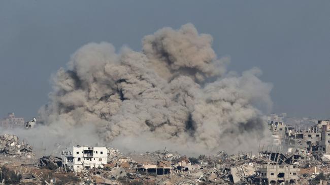 A picture taken from southern Israel near the border with the Gaza Strip on December 9 shows smoke rising above buildings during an Israeli strike in Gaza. Picture: AFP