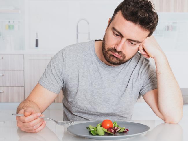 Worried man hungry and starved with salad