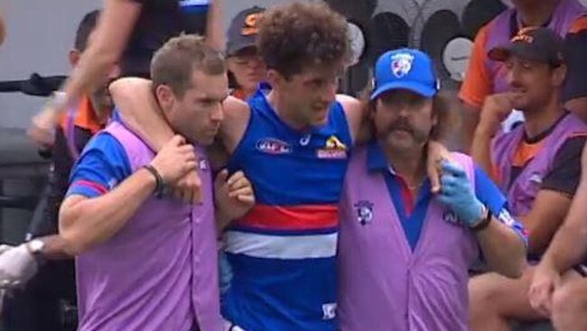 Tom Liberatore is helped from the ground after injuring his knee.