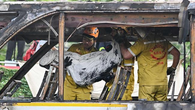 A rescue worker carries the wrapped-up body of a victim. Picture: AFP