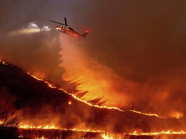 Water is dropped by helicopter on the Kenneth Fire in the West Hills section of Los Angeles, Thursday, Jan. 9, 2025. (AP Photo/Ethan Swope)