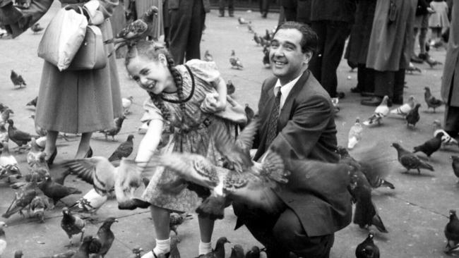 Journalist Samela Harris with father Max Harris feeding pigeons in Trafalgar Square in London.