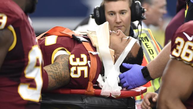 Washington Redskins' Dashaun Phillips (35) is carted off the field by first responders as Ricky Jean Francois (99) watches in the first half of an NFL football game against the Dallas Cowboys, Sunday, Jan. 3, 2016, in Arlington, Texas. Phillips was injured while helping stop Cowboys running back Darren McFadden on a running play. (AP Photo/Michael Ainsworth)