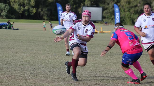 GCDRU (Gold Coast Rugby) first grade clash between Helensvale Hogs (pink) and Nerang Bulls. (white). Matt Monahan passes. Pic Mike Batterham