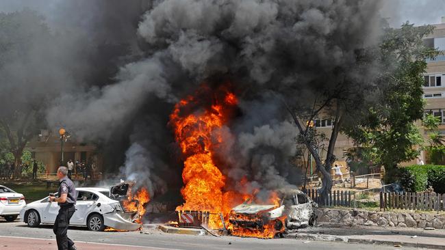 Vehicles ablaze after a rocket was launched from the Gaza Strip. Picture: AFP