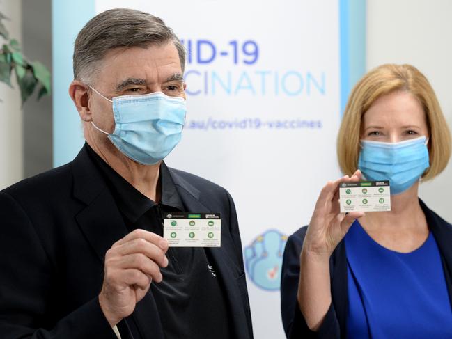 Chief Medical Officer Dr Brendan Murphy and former prime minister Julia Gillard display their inoculation cards. Picture: Andrew Henshaw