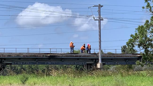 Police and Aurizon staff inspecting the train bridge at Gladstone where the tragedy occurred.