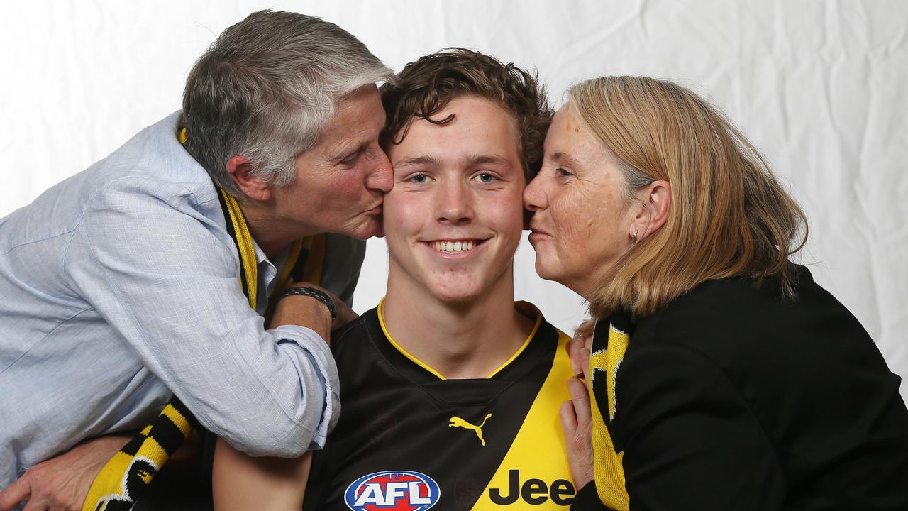 Riley Collier-Dawkins gets a kiss from his mums Chris and Jacinta. Pic: Michael Klein