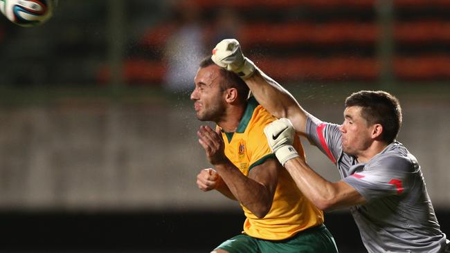 Mat Ryan of the Socceroos clears the ball over Ivan Franjic.