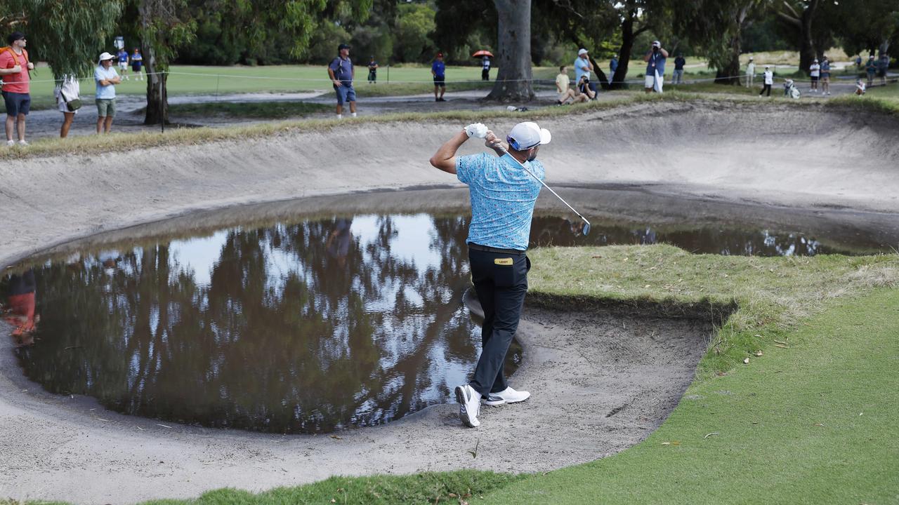 Marc Leishman plays from a free drop after landing in a water-filled bunker. Picture: Michael Klein