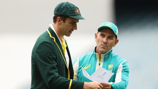 MELBOURNE, AUSTRALIA - DECEMBER 26: Pat Cummins of Australia and Australia head coach Justin Langer are seen with England's team list during day one of the Third Test match in the Ashes series between Australia and England at Melbourne Cricket Ground on December 26, 2021 in Melbourne, Australia. (Photo by Robert Cianflone/Getty Images)