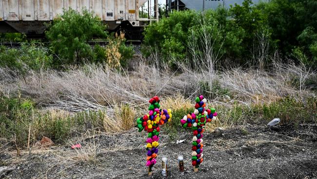 Crosses and candles have been displayed at the spot where a tractor-trailer was discovered with deceased migrants inside, outside San Antonio in Texas. Picture: Chandan Khanna/AFP