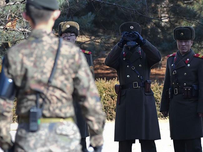 North Korean soldiers look at South next to a spot where a North Korean defected crossing the border. Picture: Getty Images