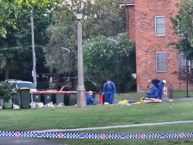 Forensics officers scoured the contents of rubbish bins on the street.