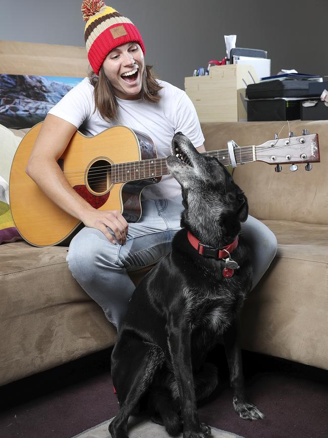 Crows AFLW co-captain Chelsea Randall plays her guitar to her dog Koda. She has signed a two-year deal to stay at the Crows. Picture: Sarah Reed