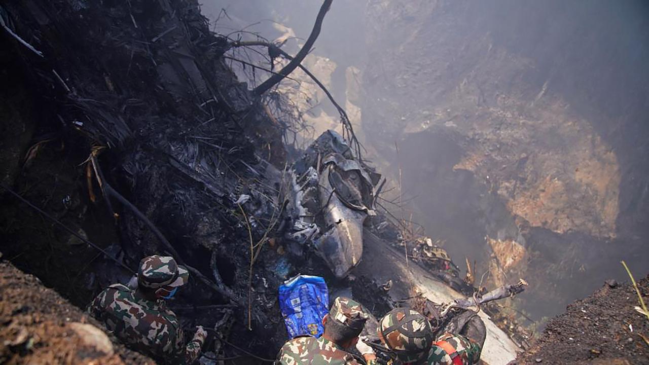 Rescuers inspect the site of a plane crash in Pokhara on January 15, 2023. Picture: Yunish Gurung/AFP