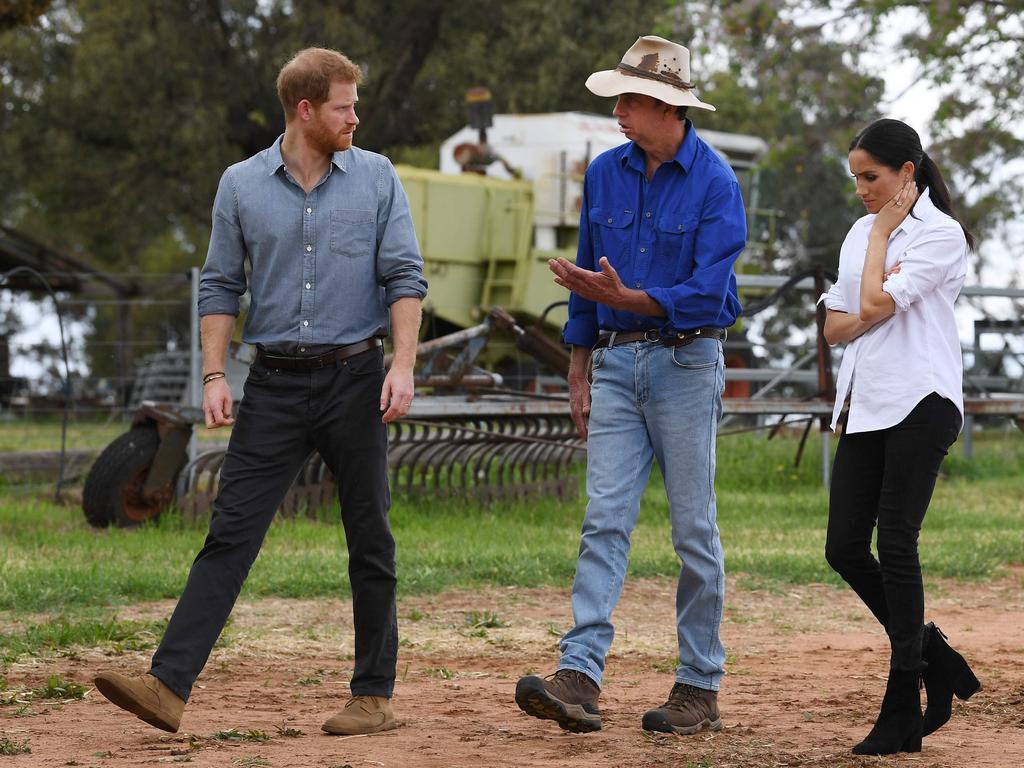 Prince Harry (L) and Meghan chat with farmer Scott Woodley (C) during a visit to his family's drought-affected farm called Mountain View near Dubbo on October 17. Picture: Dean Lewins