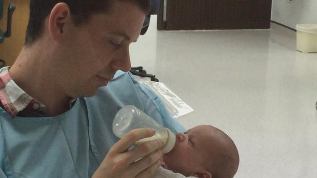 Worrying vigil: Sean feeds sick Ava in hospital as they wait for her to be well enough to get to Australia. Picture: Supplied by Channel Nine