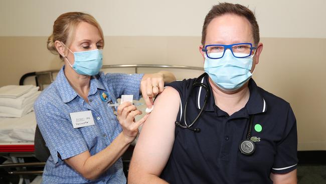 Nurse Alison Clancy gives Associate Professor Paul Griffin, an infectious disease expert, the AstraZeneca vaccine. Picture: Annette Dew