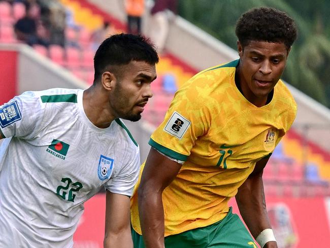 Australia's Kusini Yengi (R) and Bangladesh's Md Saad Uddin fight for the ball during the 2026 FIFA World Cup Asian qualification football match between Bangladesh and Australia at the Bashundhara Kings Arena in Dhaka on June 6, 2024. (Photo by MUNIR UZ ZAMAN / AFP)