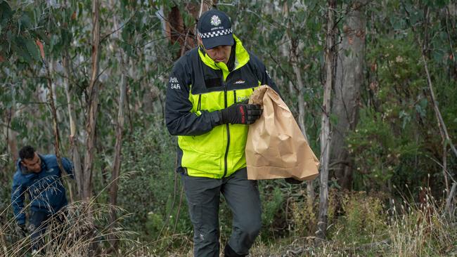 Police remove bags of potential evidence during their search. Picture: Jason Edwards