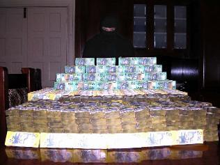 Surfer Shayne Hatfield poses with a huge pile of cash in 2005 ... he was part of a cocaine trafficking syndicate.