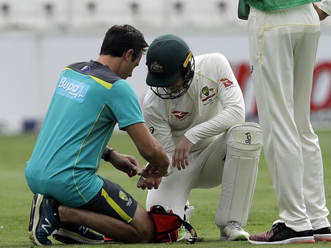 Paine receives treatment before returning to his post behind the stumps. Picture: AP
