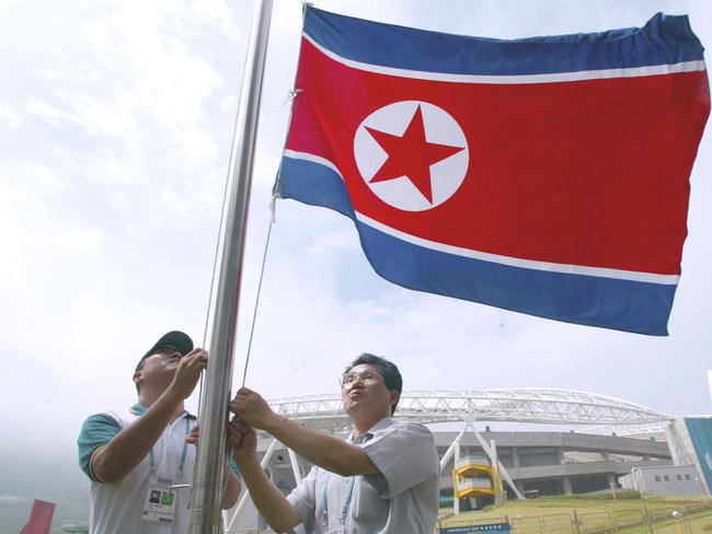 DAEGU, SOUTH KOREA - AUGUST 20: Staff of the 22nd Daegu Summer Universiade Organizing Committee set up the North Korean national flag after North Korea decided to participate in the Universiade Games outside of the main stadium in Daegu, south of Seoul, South Korea August 20, 2003. The North Korean delegation, accompanied by 24 journalists, arrived in South Korea to participate in the Student games to be held in Taegu between August 21-31 having changed its mind over boycotting the games following an apology from the South Korean president over the burning of a North Korean flag during protests in Seoul last week. (Photo by Chung Sung-Jun/Getty Images).