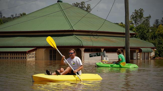 North Ipswich residents Martin Lowe (l) and his son Kurt (r) inspect the flooded Pelican and Canning Street's in North Ipswich. Picture: Patrick Hamilton