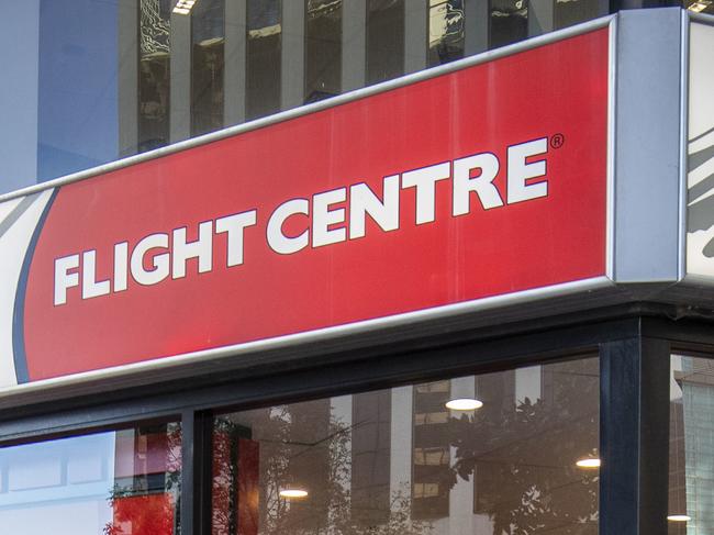 A cyclist rides past a Flight Centre store wearing a mask to protect themselves from Covid-19, Brisbane, Friday, May 1, 2020. (AAP Image/Glenn Hunt) NO ARCHIVING