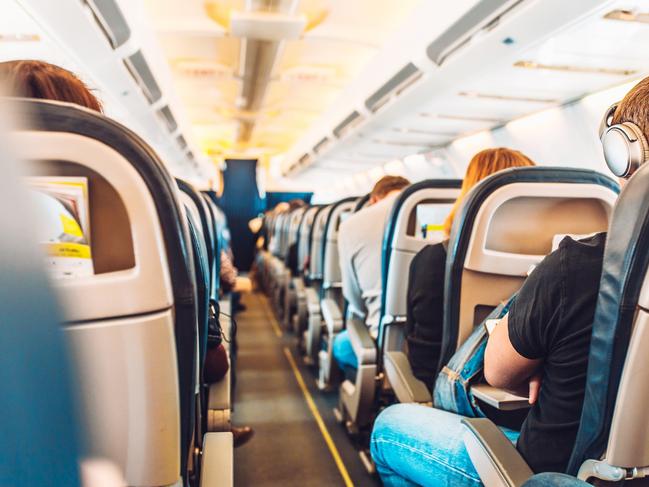 Inside view of the cabin of an airliner with rows of seats - airplane with passengers in flight.Escape 2 June 2024Kendall HillPhoto - iStock