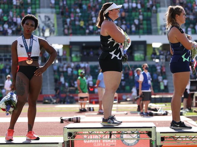 EUGENE, OREGON - JUNE 26: Gwendolyn Berry (L), third place, turns away from U.S. flag during the U.S. National Anthem as DeAnna Price (C), first place, and Brooke Andersen, second place, also stand on the podium after the Women's Hammer Throw final on day nine of the 2020 U.S. Olympic Track & Field Team Trials at Hayward Field on June 26, 2021 in Eugene, Oregon. In 2019, the USOPC reprimanded Berry after her demonstration on the podium at the Lima Pan-American Games. (Photo by Patrick Smith/Getty Images)