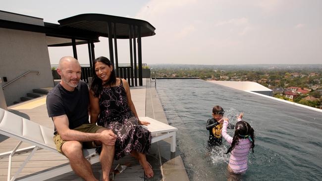 Luke and Marina Vanston with children Zeke and Harper at the rooftop pool of their inner-suburban Melbourne apartment block. Picture: Stuart McEvoy